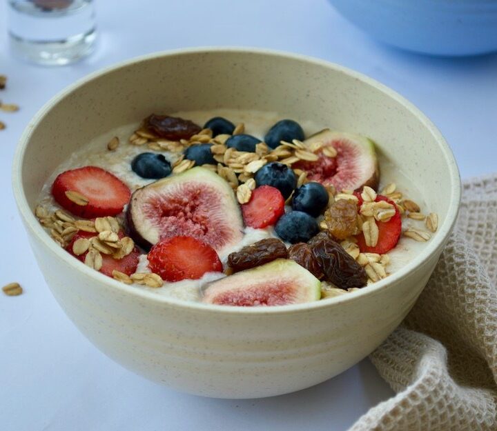 Bowl refrescante y nutritivo de ingredientes orgánicos como la avena en hojuelas, con frutas frescas como los higos, fresas arándanos, frutos secos, canela y miel con Ka Wellness Coach online
