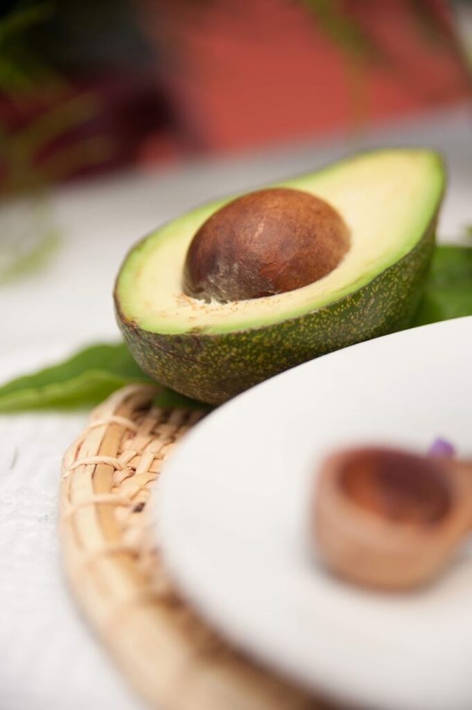 Aguacate cortado sobre una superficie natural, representando la alimentación consciente, el equilibrio y el bienestar holístico.
