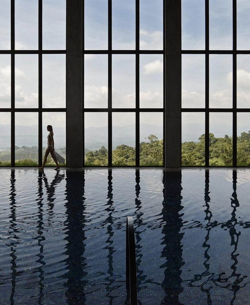 Piscina climatizada techada con vista a la selva y al mar, espacio de retiro holístico de bienestar y conexión profunda con la naturaleza.