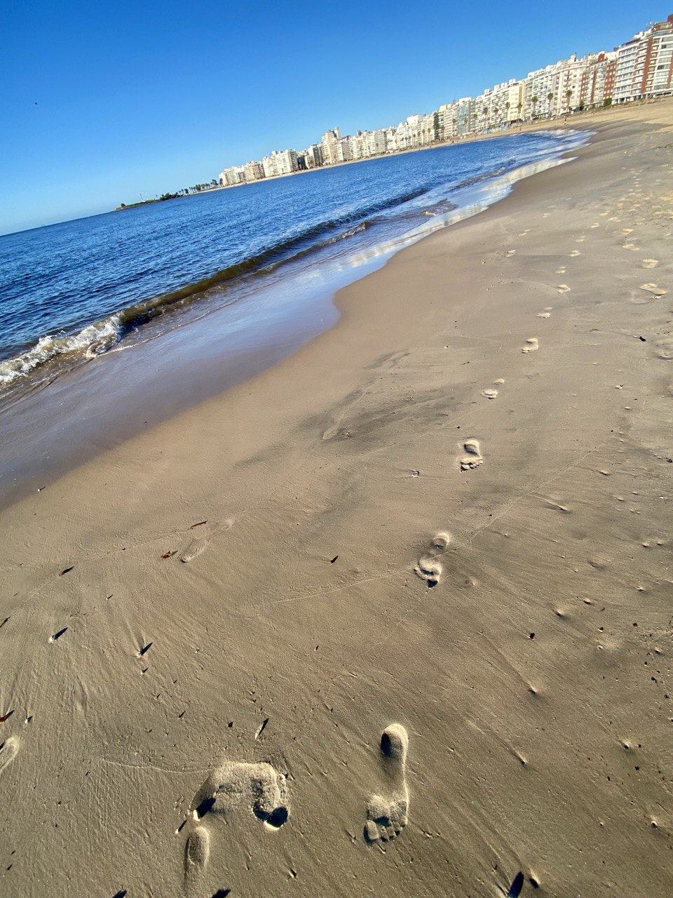 Huella en la arena junto al mar en Montevideo – Reconexión con la naturaleza y bienestar holístico con Ka Wellness Coach Online