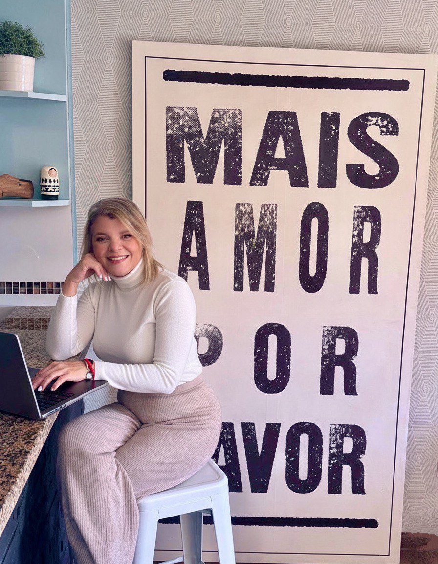 Ka sonriente y feliz mientras trabaja en su computadora desde la barra de su casa, en sesiones online, irradiando energía positiva y propósito